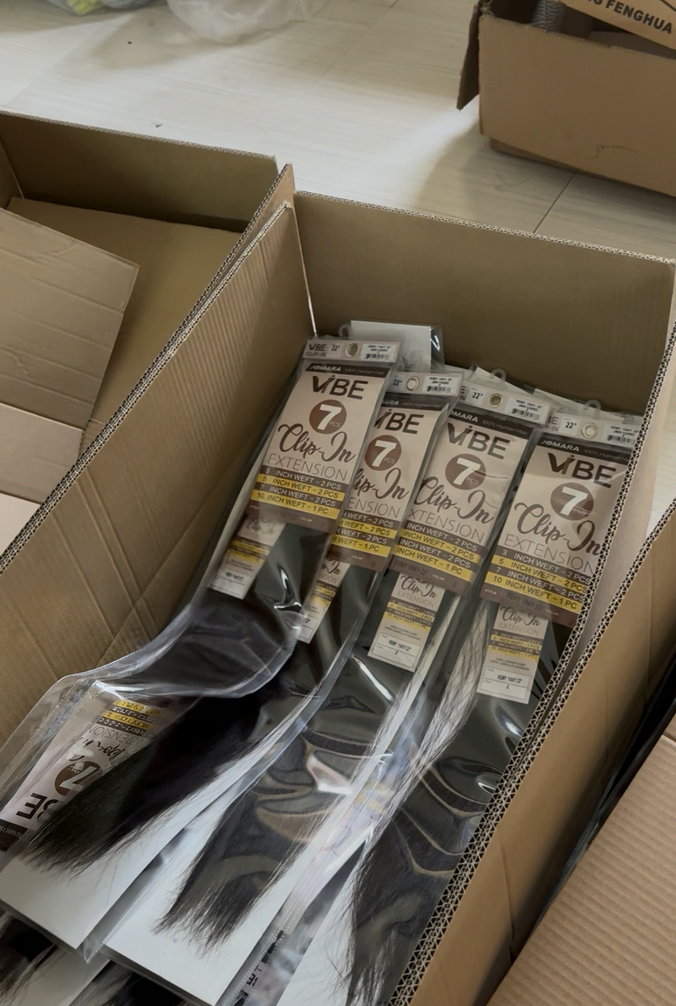 Cartons filled with labeled clip-in hair extension packages ready for shipment